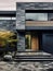 Modern minimalist private black house decorated with stone tiles mosaic cladding. Front entrance wooden door with stone landing.