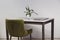 Modern minimalist workplace. Green velours armchair and loft table with laptop