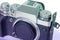 Modern mirrorless digital camera in retro style close-up, black, metal, body without a lens on an isolated white background,
