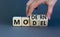 Modern model symbol. Businessman turns wooden cubes and changes the word `model` to `modern`. Beautiful grey table, grey