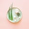 Modern moisturizing cosmetic products with fresh aloe vera leaves on light green tray on pastel pink background. Top view. Modern