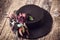 Modern mousse black color cake. Chocolate velour cake with floristic decoration on wooden board