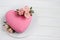 Modern  mousse cake .Heart shape  cake covered with pink chocolate velour and decoraited of pink roses.White wooden board.Concept