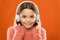Modern music is her life style and pleasure. Little modern girl wearing bluetooth headphones. Small child listening to