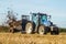 Modern New Holland tractor Tractor spreading manure on fields