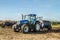 Modern New Holland tractor Tractor spreading manure on fields