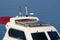 Modern new solar panels on top of small white and dark red boat next to multiple electronic gadgets from signal light to sensors