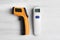 Modern non-contact infrared thermometers on wooden background, flat lay