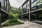 modern office building with glass windows and minimalist interior, surrounded by lush greenery