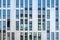 Modern office building reflecting in facade of stainless steel and mirrored glass