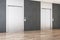 Modern office lobby interior with steel elevators, wooden flooring and tile wall.