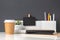 Modern office stationery on white table and dark grey wall.pencil,ruler,pen,pencil box,coffee cup and blackboard with plant.Mock