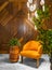 Modern orange armchair, tall rounded wooden planter with green bushes, tall glass chandelier, and wood cladding wall