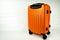 Modern orange suitcase for vacation or business