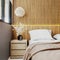 Modern oriental style bedroom interior with wooden panel wall with cove light, nightstand close up, brown tones, hotel room