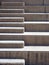 Modern outdoor concrete ascending steps with raised area for seating in contrasting sunlight and shadow