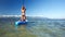 Modern paddleboard and girl in bikini floats back view