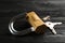 Modern padlock with keys on black wooden table, closeup