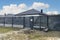 Modern panel fencing in anthracite color, visible spans and a gate with a letterbox, view from the garden.