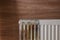 Modern panel radiator affected by rust on wooden background