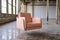 modern peach armchair with brass legs in a highceiling loft, concrete floors