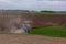 A modern powerful tractor plows a field.