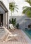 Modern private pool villa terrace with beach chairs, swimming pool and tropical outdoor plants