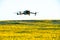 A modern quadcopter flies over a field of sunflowers against the sunset. The use of modern technologies in the agro-industrial