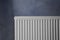 Modern radiator on grey wall. Central heating system