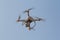 Modern RC Drone / Quadcopter with camera flying in a bright and clear blue sky. New technology in the aero photo shooting