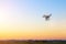 Modern RC UAV Drone / Quadcopter with camera flying on a clear s