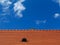 modern red brown sloped clay roof with vent under blue sky