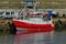 Modern Red Fishing boat alongside the wharf.