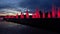 Modern red lit park fountains against late sunset sky. Architectural LED lighting. Super slow motion shot