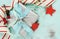 Modern red and white Christmas decorations on aqua blue wood background, with silver gift closeup.