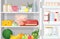 Modern refrigerator with opened door full of various daily food - meat, dairy products, eggs, fresh fruits and berries