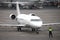 Modern regional airliner on apron of the airport. Airport traffic controller ground crew gives commands to an airplane