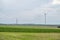 Modern renewable energy wind turbines next to wind turbine construction site, agricultural field in front, hot air balloon in