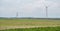 Modern renewable energy wind turbines next to wind turbine construction site, agricultural field in front, hot air balloon in