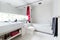 Modern renovated white mosaic tiled family bathroom with red and