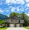 Modern residential duplex house with concrete driveway on cloudy sky background