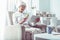 Modern retired woman holding bank card while shopping online via tablet