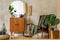 Modern retro composition of living room interior with vintage armchair, lamp, commode, tropical leaf, plant, decoration.