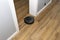 A modern robotic vacuum cleaner running on vinyl panels, an autonomous cleaning robot.