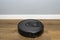 A modern robotic vacuum cleaner running on vinyl panels, an autonomous cleaning robot.