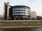 Modern round building with interesting architecture on sunny day.