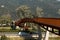 Modern rusted pedestrian and bicycle bridge with flowing Ticino river below. Beautiful panorama,