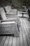 Modern Rustic rocking chairs lined up on Deck - Black and White - Focus on foreground