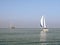 Modern sailboat and traditional three masted clipper sailing on IJsselmeer lake, Netherlands