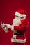 Modern Santa Claus using tablet pc over red background. Christma